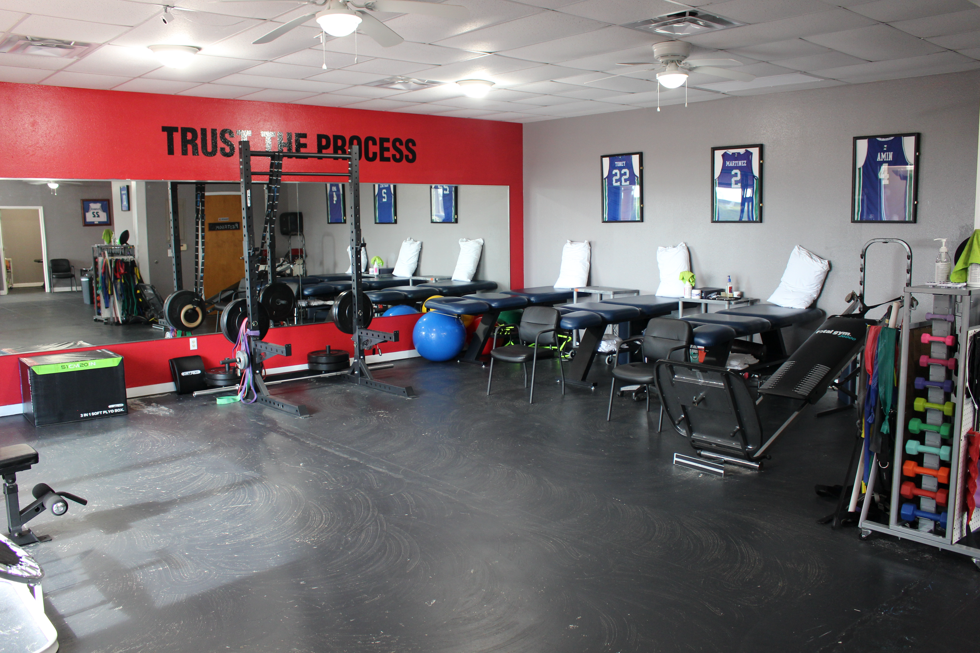 The Training Room Padre Island Trust The Process wall with power rack and PT tables