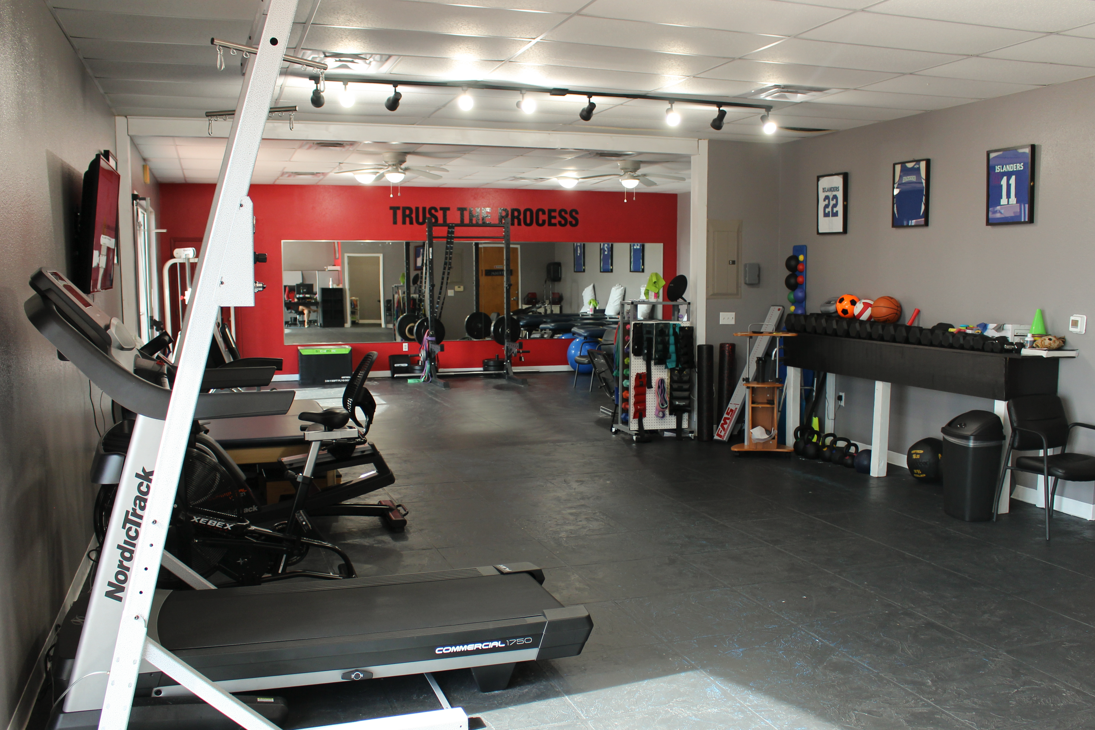 The Training Room Padre Island full facility with NordicTrack treadmill and framed jerseys