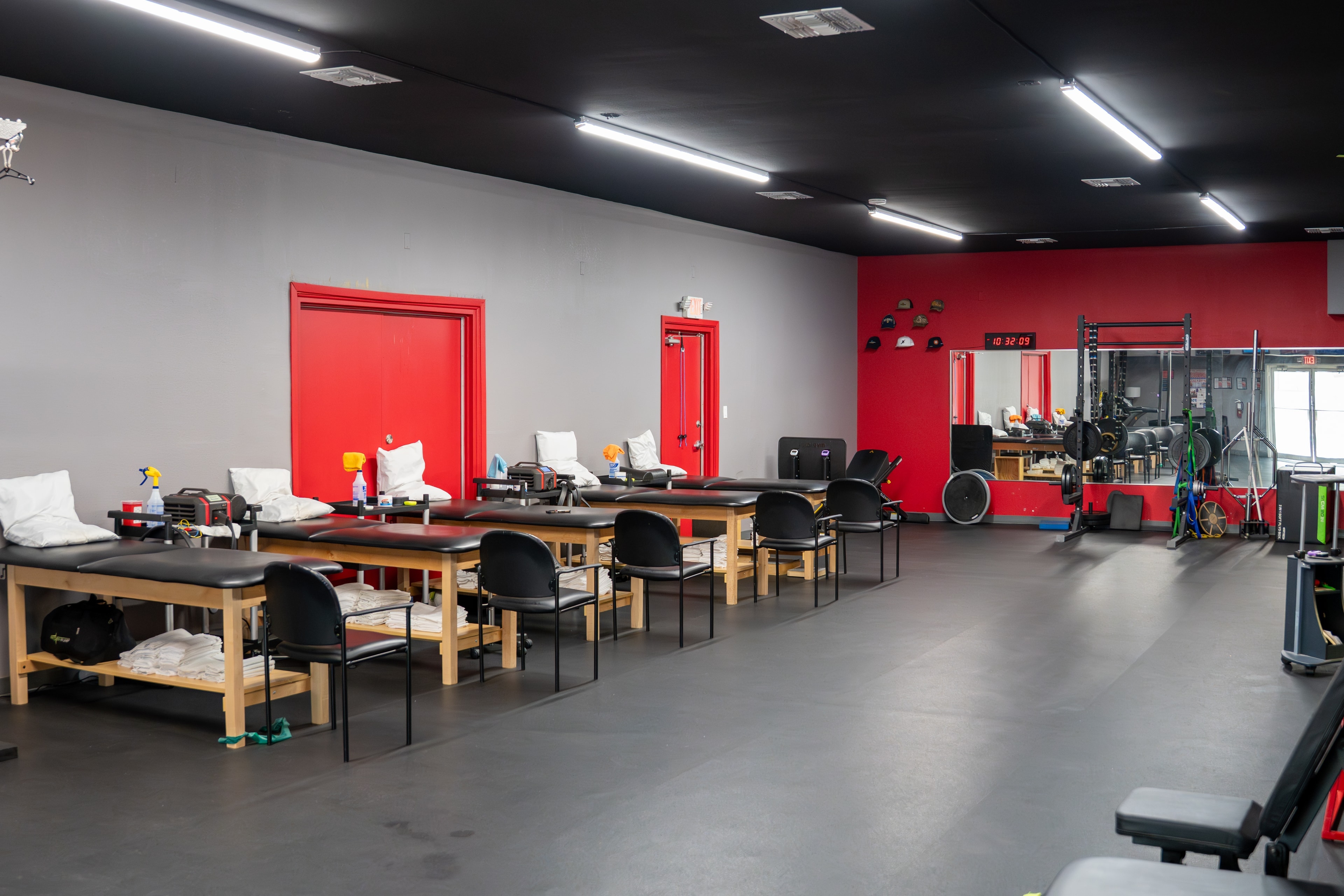 The Training Room Portland full PT floor with treatment tables and red doors