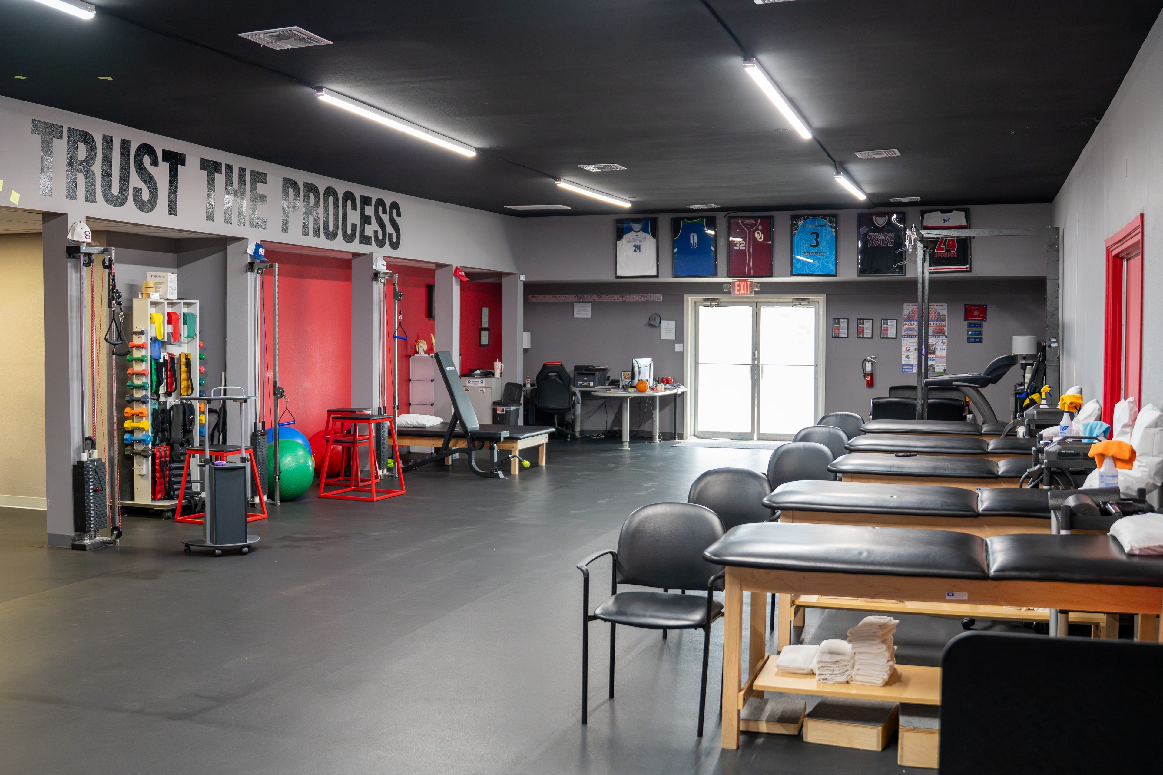 The Training Room Portland Trust The Process wall with framed jerseys and PT tables