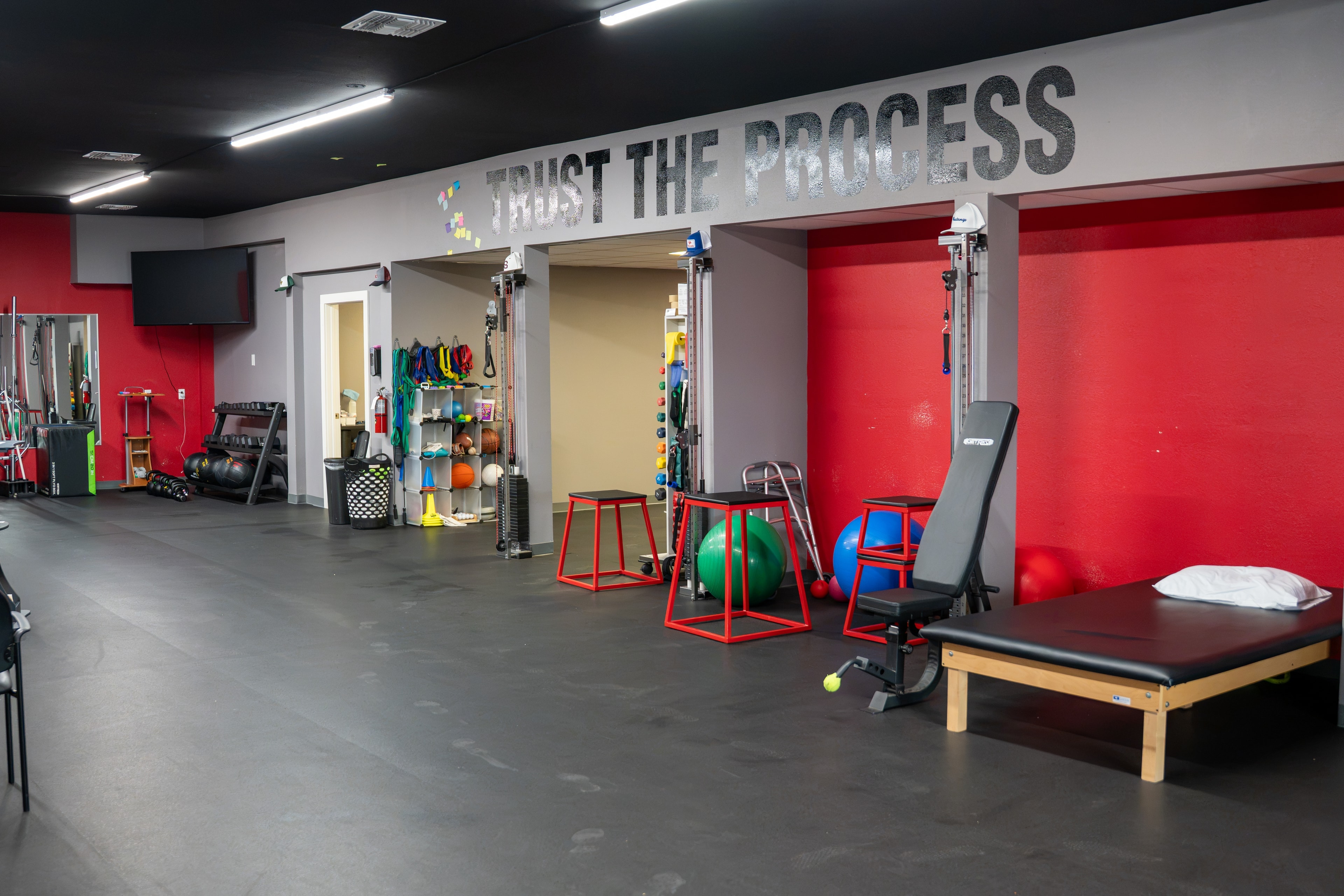 The Training Room Portland Trust The Process wall with exercise equipment and PT table
